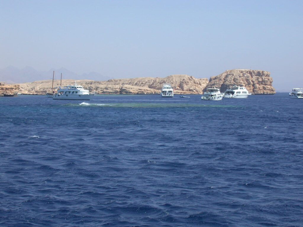 Łodzie nurkowe na kotwicy przed jasnymi klifami Ras Mohammed, nad Shark i Yolanda Reef