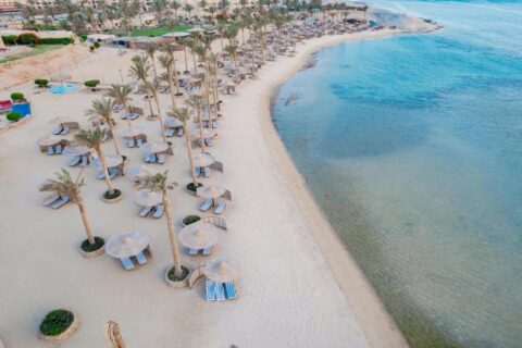 Plaża Blend Elphistone Resort z lotu ptaka, z palmami, słomianymi parasolami i turkusowym morzem