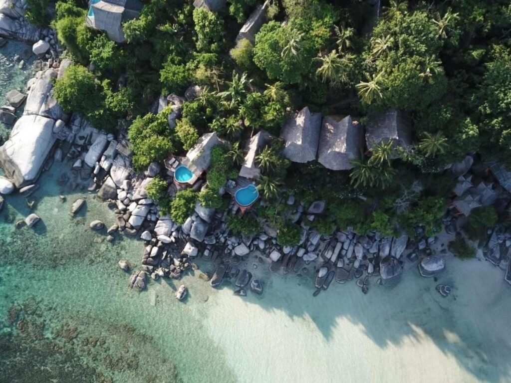 Koh Tao Cabana z lotu ptaka: domki wśród drzew, skały i plaża z białym piaskiem