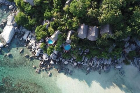 Koh Tao Cabana z lotu ptaka: domki wśród drzew, skały i plaża z białym piaskiem