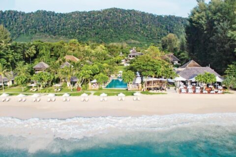 Layana Resort widziany od strony morza: plaża, białe parasole, basen i dachy pod palmami