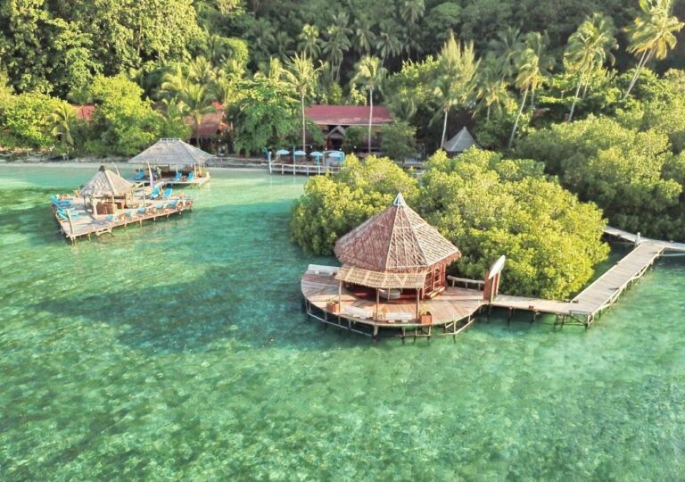 Raja Ampat Dive Lodge z lotu ptaka: pomosty na palach i czerwone dachy pod palmami