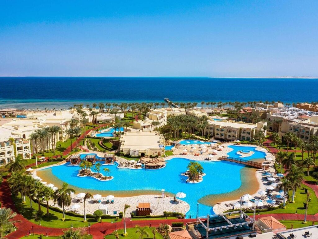 Rixos Sharm El Sheikh z lotu ptaka: baseny w kształcie laguny, palmy i Morze Czerwone