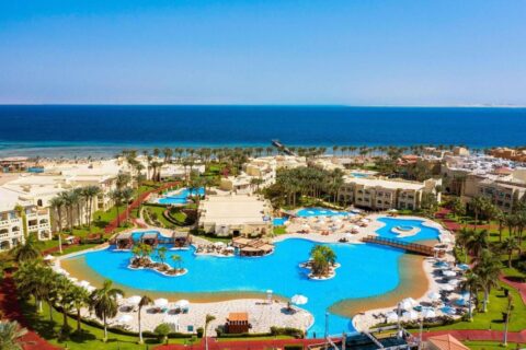 Rixos Sharm El Sheikh z lotu ptaka: baseny w kształcie laguny, palmy i Morze Czerwone